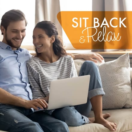 Alliance Lending Services post reading "Sit Back & Relax" over a couple on a sofa laughing together with a laptop between them